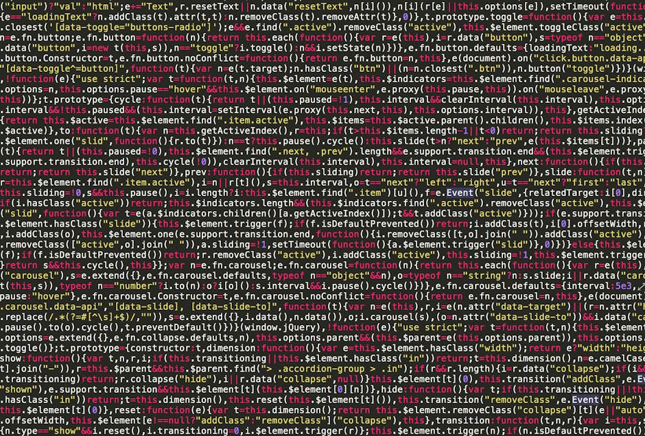 A close-up view of a person’s hands typing on a laptop keyboard. The laptop screen displays lines of code in a dark-themed text editor, indicating programming or web development activity. The backgrou